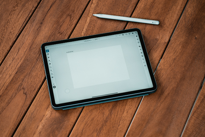 black ipad on brown wooden table